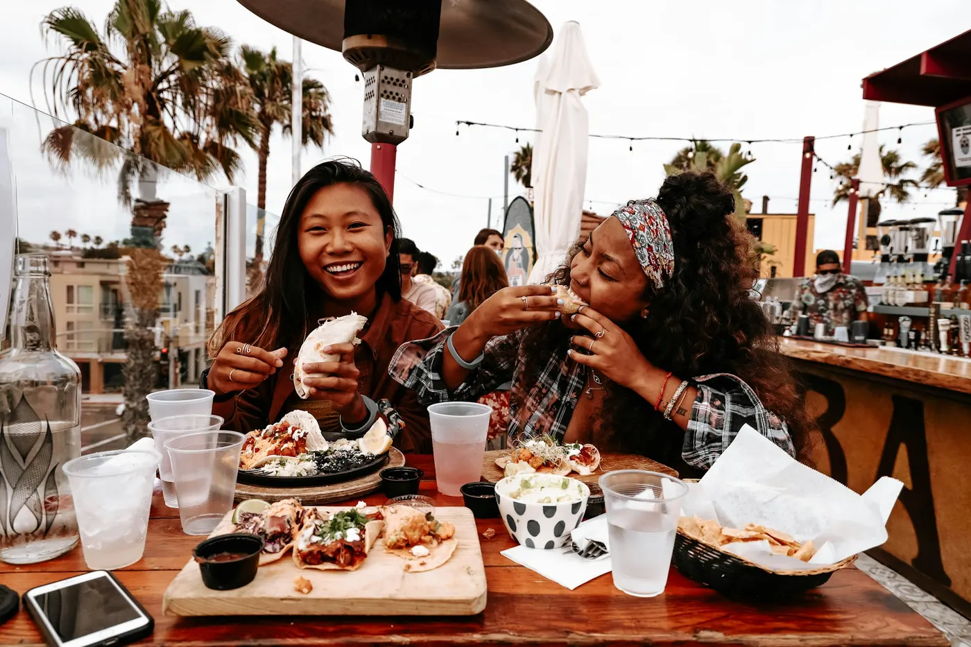 Two friends laughing with tacos