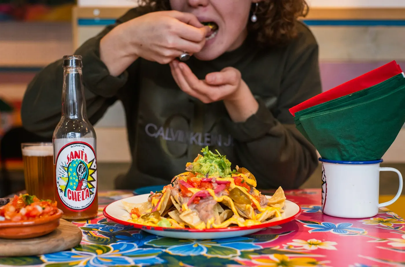 Nachos and a cold drink on a bright tablecloth