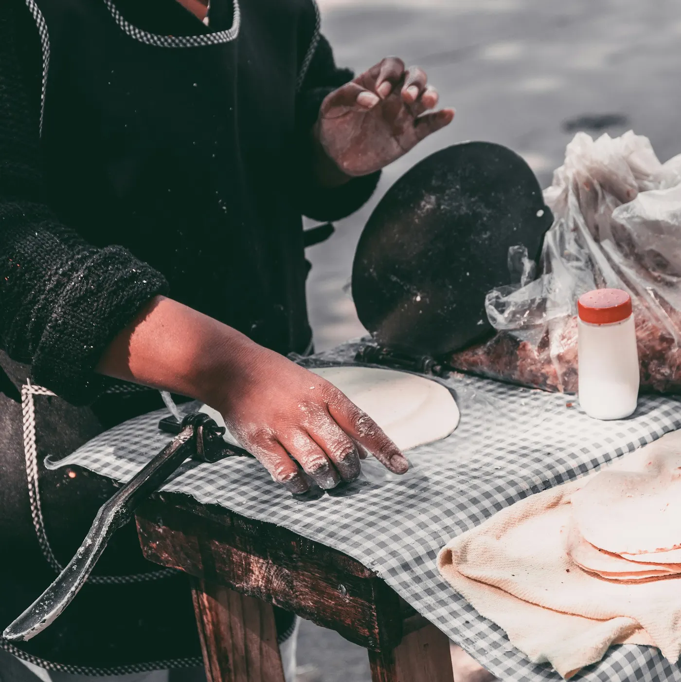 Hands pressing a fresh tortilla
